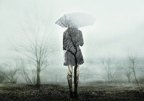 Kvinde står i gråvejr med paraply