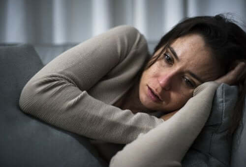 Kvinde med kognitivt opmærksomhedssyndrom græder på sofa