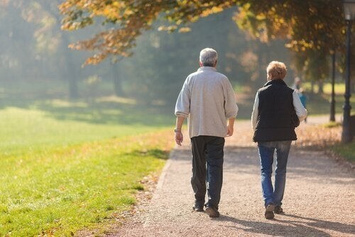 Ældre ægtepar går en tur sammen i solskinsvejr 