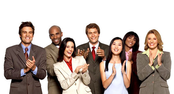 Personer i pænt arbejdstøj står og klapper som eksempel på at få en kompliment