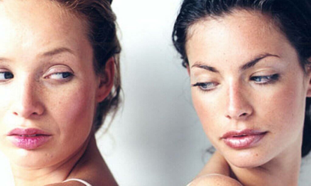 Kvinde med ryggen mod hinanden ser på hinanden med misundelse