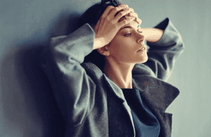 Frustreret kvinde, der læner sig op ad væg