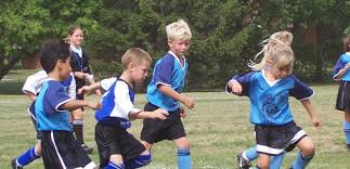 Børn på fodboldbane nyder fordele ved, at børn går til holdsport