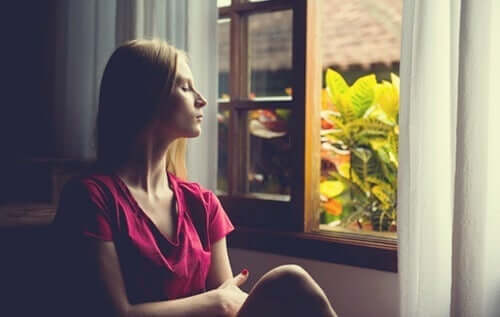 kvinde ser ud af vindue for at undgå altid at bruge de samme løsninger på hendes problemer
