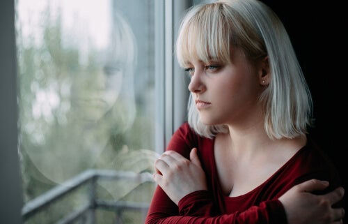 trist kvinde, der kigger ud af vindue