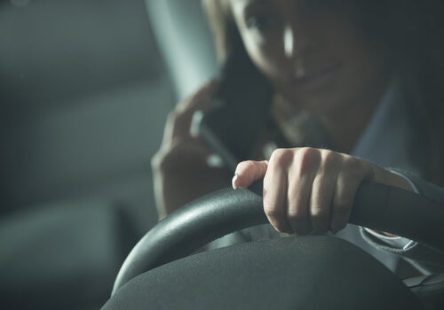 Kvinde taler i mobil bag rattet