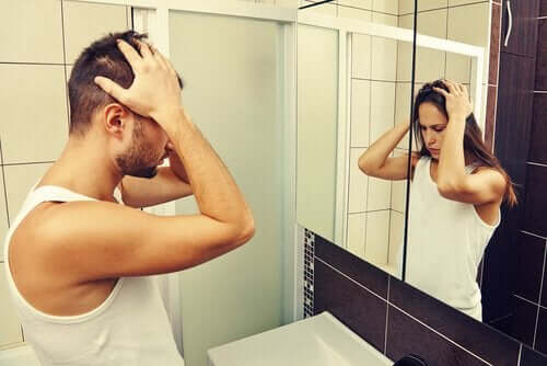 Kønsdysfori illustreres af mand, der ser kvinde i spejl