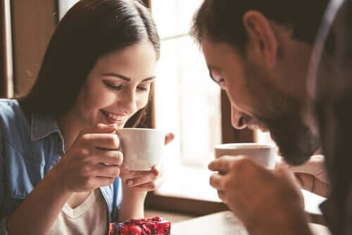 den dyadiske justeringsskala anvendes af smilende par, der drikker kaffe sammen