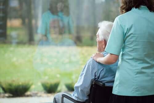 Mand, der ser ud af vindue, oplever demenssygdom