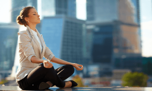 Kvinde mediterer i en storby