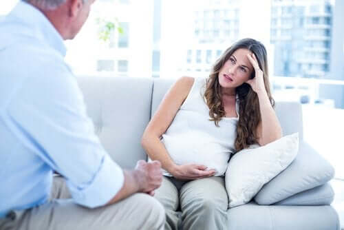 Gravid i sofa, der snakker med ældre mand