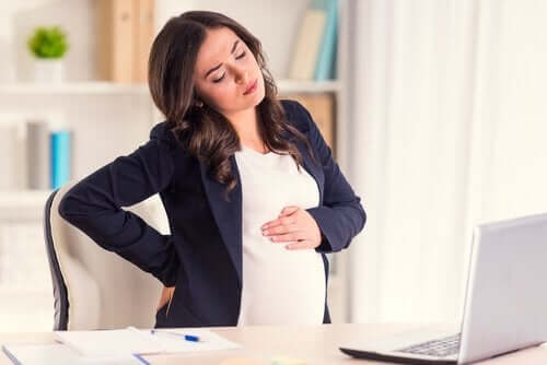 Gravid med lændesmerter foran bærbar