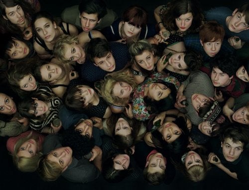 Gruppe af unge folk, der står tæt sammen og kigger op