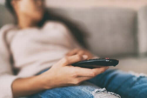 Person sidder med en fjernbetjening