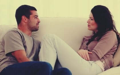 Kommunikationen i et parforhold: Par sidder sammen på sofaen og taler