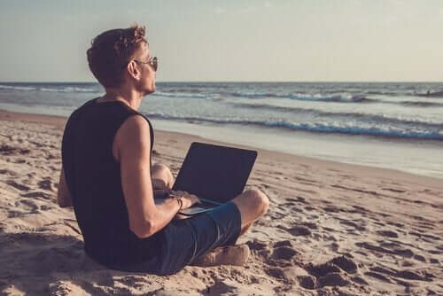 Nedgearing illustreres af mand med computer på strand