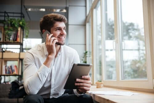 Mand med tablet, der snakker i mobil