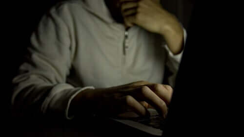 Mand ved computer i mørke