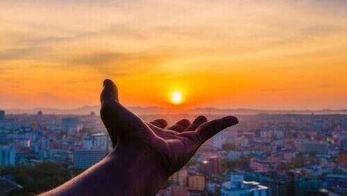 Sommertid under corona-karantænen illustreres af menneske, der rækker ud mod solen