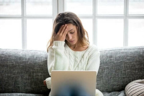 Stresset kvinde ved computer oplever frygt for at miste jobbet