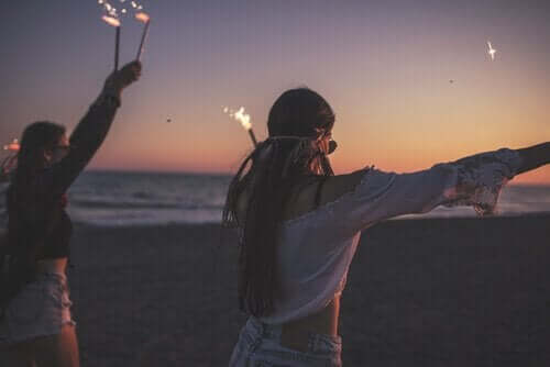 Unge på stranden med stjernekastere