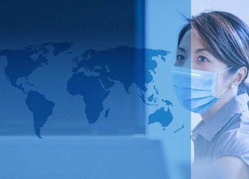 Kvinde med mundbind bag ved verdenskort