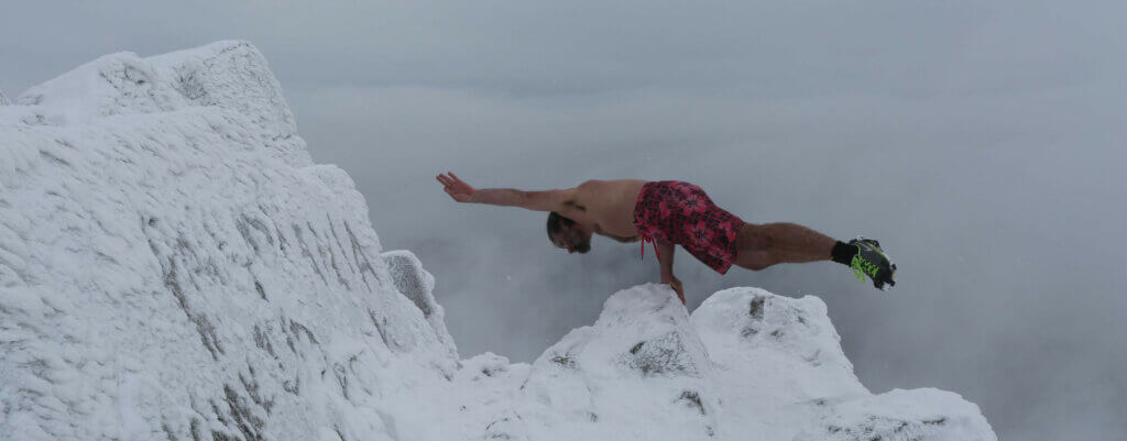 Mand balancerer på toppen af isbjerg