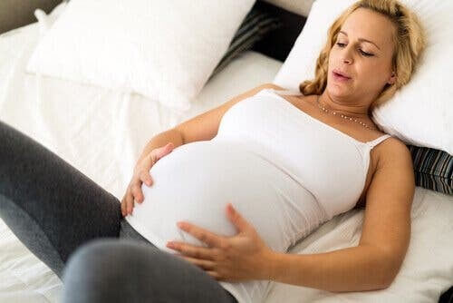 Gravid kvinde laver afslapningsøvelser 