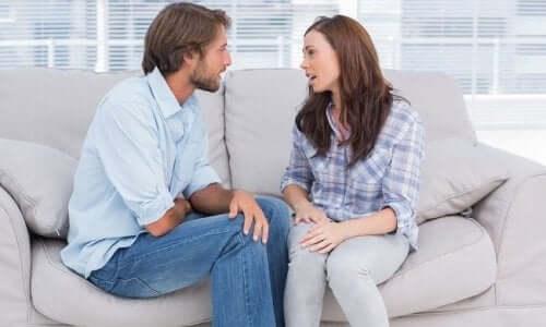 Mand og kvinde taler sammen på sofa