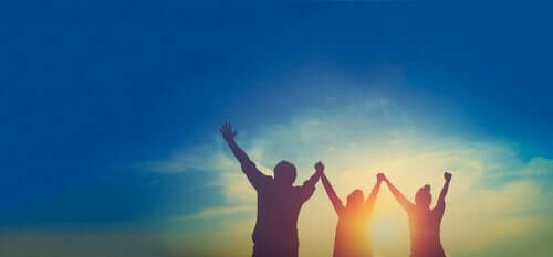 Glade mennesker hæver armene over hovedet