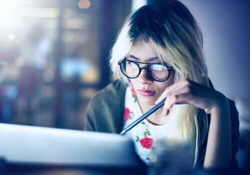 Kvinde ved computer kæmper med at arbejde og studere samtidig