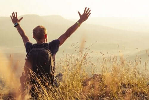 Mand med rygsæk på eng