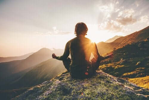 Mand mediterer i bjergene for at kunne træffe beslutninger med mindfulness