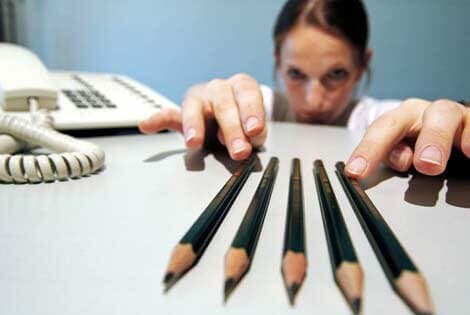 Kvinde studerer fem blyanter