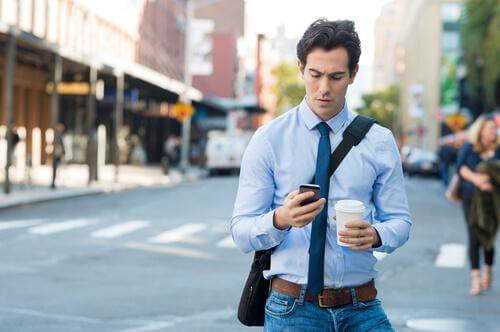 En mand med kaffe og smartphone