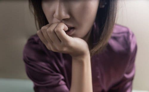 Voksne med separationsangst illustreres af kvinde, der bider negle