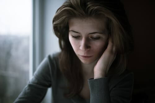 Kvinde, der sidder ved vindue