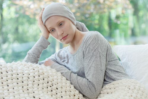 Kvinde med kræft sidder i sofa
