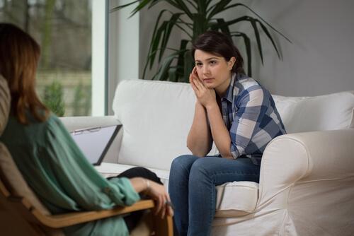 Kvinde i sofa taler med en anden kvinde