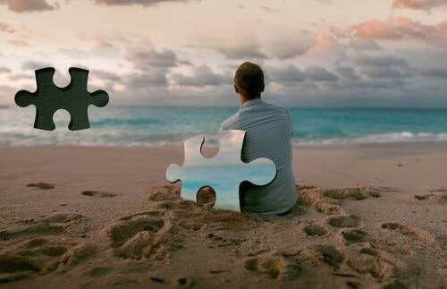 Mand sidder på stranden og kigger ud over vandet
