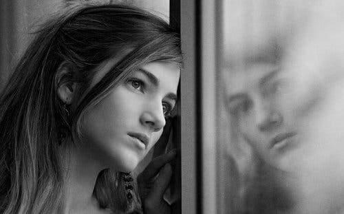 Pige, der kigger ud af vindue