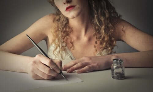 Kvinde, der er i gang med at skrive i hånden med blæk