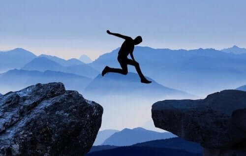 Mand, der hopper over en klippe