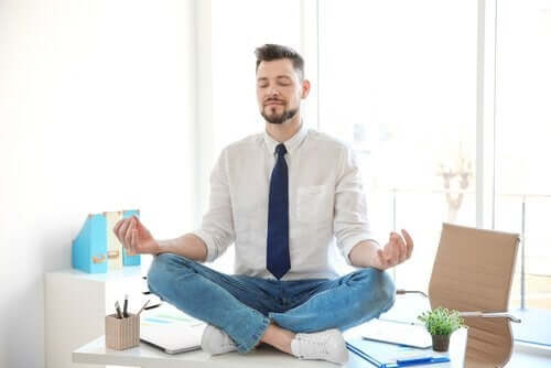 Mand, der mediterer på skrivebord