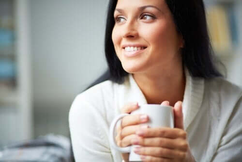 Smilende kvinde med kaffekop