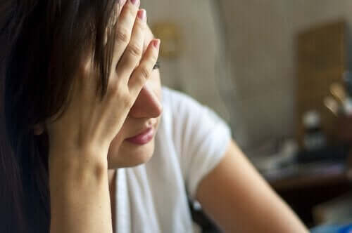 Kvinde, der tager sig til hoved, oplever forskellige typer depression