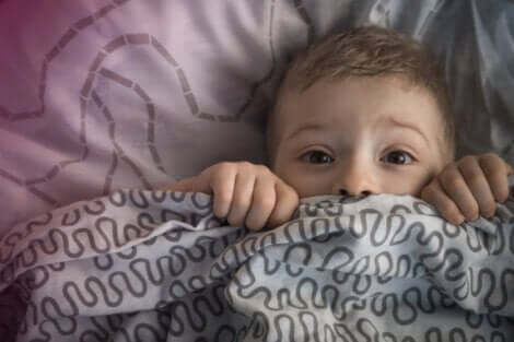 Skræmt dreng under sin dyne