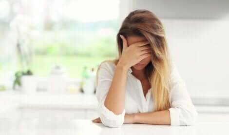 Trist kvinde ved køkkenbord