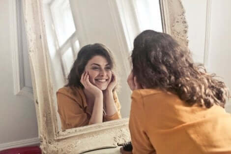 Kvinde, der smiler til sig selv i et spejl
