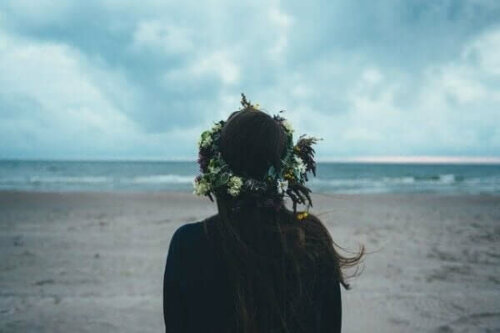 Kvinde med blomsterkrans i håret ved stranden